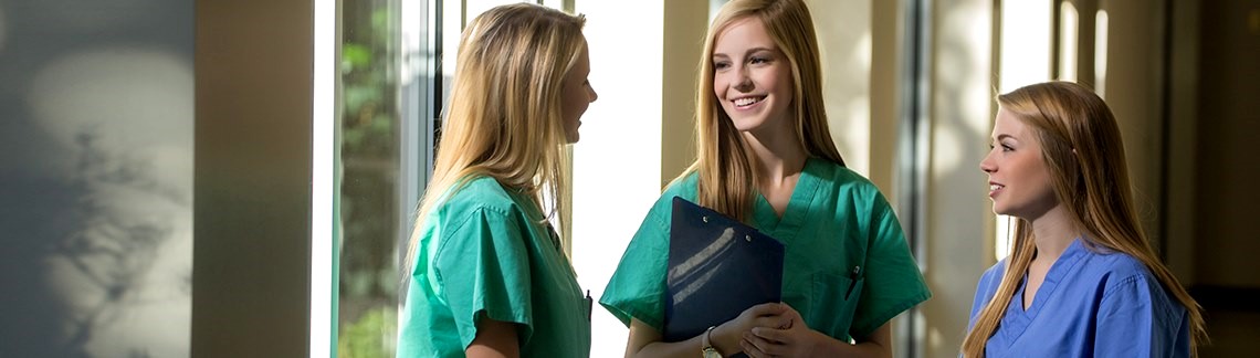 three medical staff students dressed in scrubs